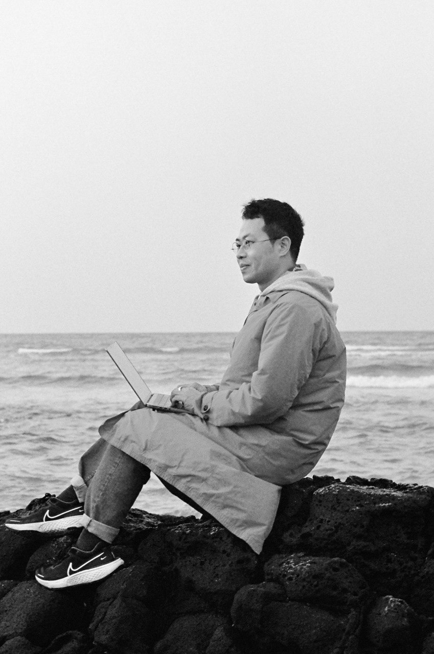 Jaeyong typing nearby the sea